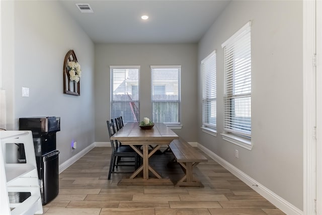 dining room with wood tiled floor, visible vents, baseboards, and recessed lighting