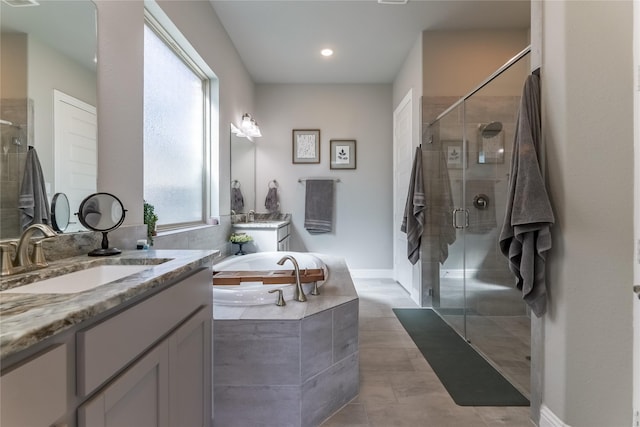 bathroom featuring a garden tub, two vanities, a sink, and a shower stall