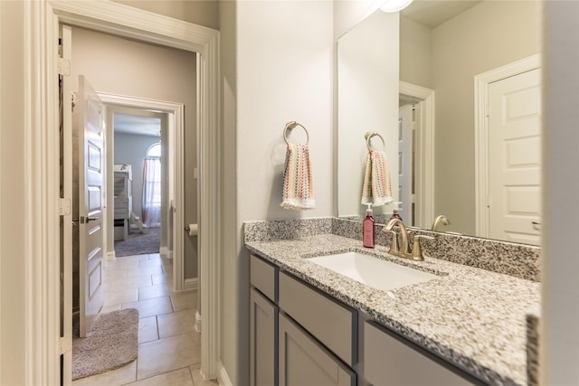 bathroom featuring vanity, baseboards, and tile patterned floors