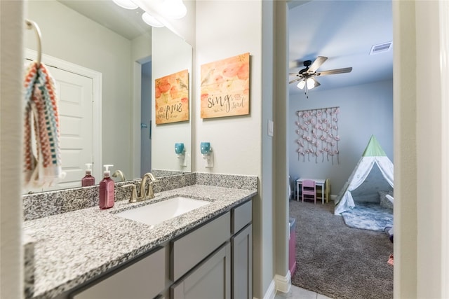 bathroom with baseboards, visible vents, a ceiling fan, and vanity