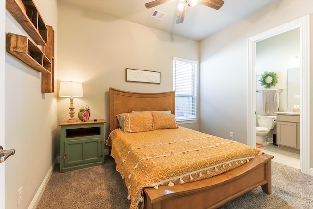 bedroom featuring visible vents, baseboards, a ceiling fan, ensuite bath, and carpet floors