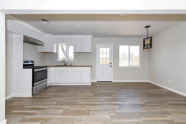 kitchen with stainless steel range with electric stovetop, under cabinet range hood, visible vents, and white cabinets