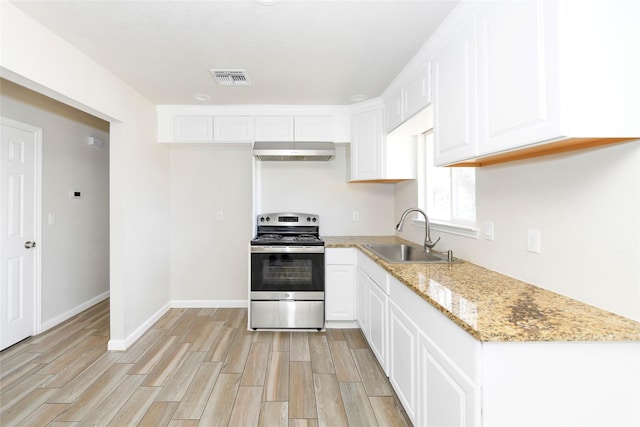 kitchen with under cabinet range hood, wood finish floors, a sink, visible vents, and stainless steel electric stove