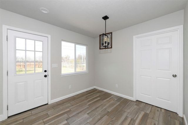 unfurnished dining area with baseboards and wood finish floors