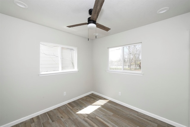 spare room featuring ceiling fan, baseboards, and wood finished floors