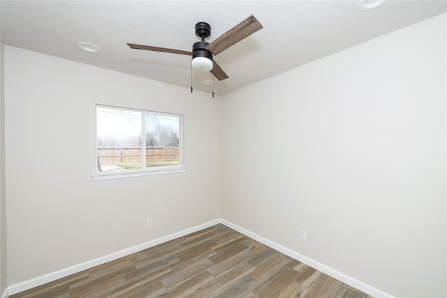 spare room with ceiling fan, baseboards, and wood finished floors