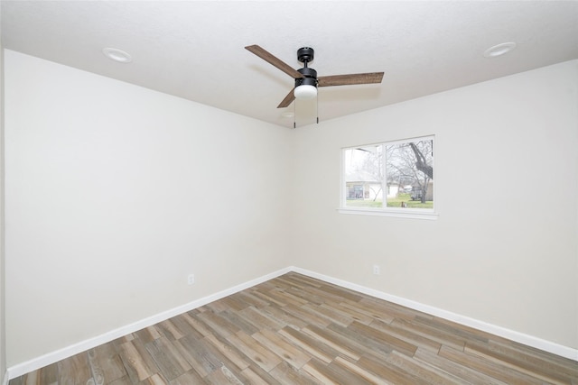 unfurnished room with a ceiling fan, baseboards, and wood finished floors