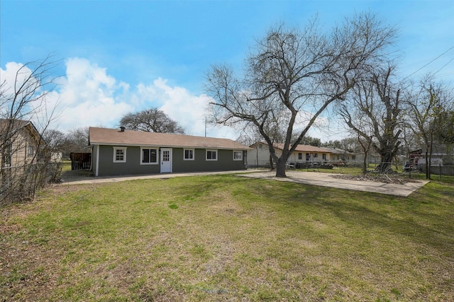 back of property featuring a lawn, fence, and stucco siding