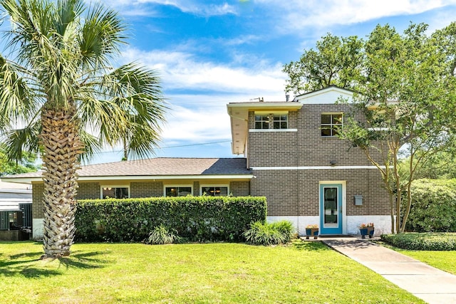 127 Bonita Ave, Galveston, TX 77550 - tri-level home featuring cooling unit, a front lawn, and brick siding