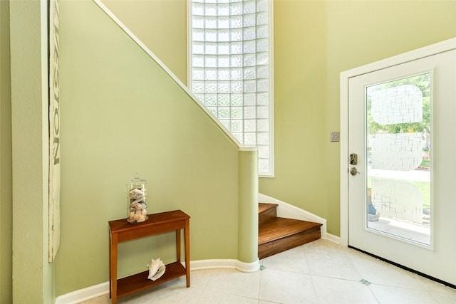 doorway to outside featuring baseboards, stairway, a wealth of natural light, and light tile patterned flooring