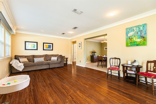 living room featuring ornamental molding, visible vents, and wood finished floors