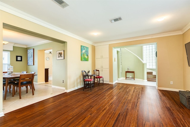 sitting room with visible vents, crown molding, baseboards, and wood finished floors