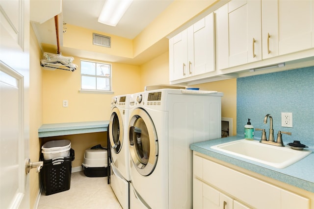 clothes washing area featuring cabinet space, light tile patterned floors, visible vents, washer and dryer, and a sink