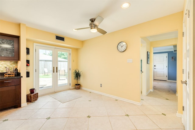 doorway with light tile patterned floors, french doors, visible vents, and baseboards