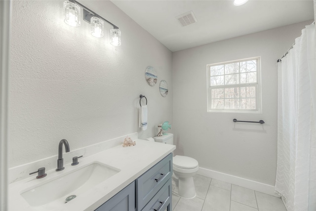 bathroom with visible vents, toilet, vanity, baseboards, and tile patterned floors