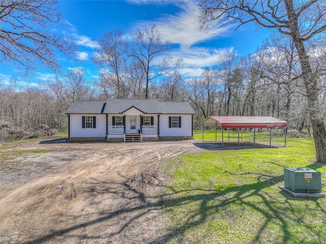 view of front of house featuring driveway, roof with shingles, covered porch, a front yard, and a detached carport