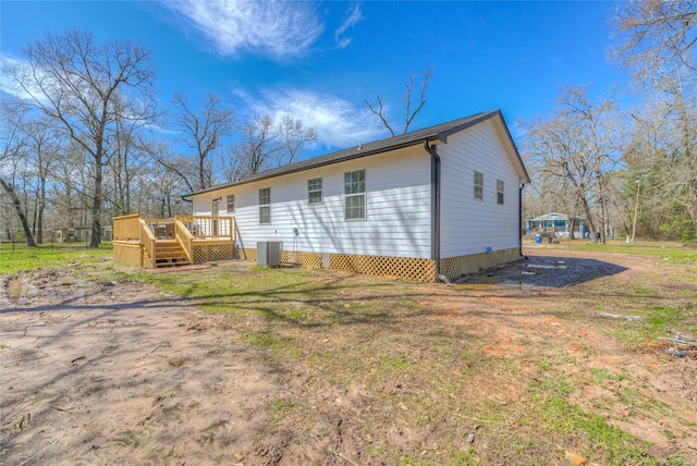 view of side of home with a deck and central AC unit