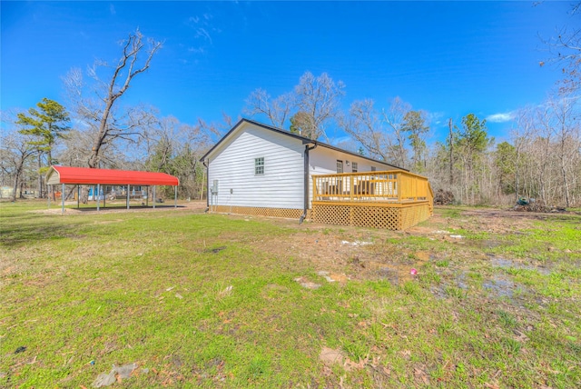 rear view of house with a carport, a lawn, and a wooden deck