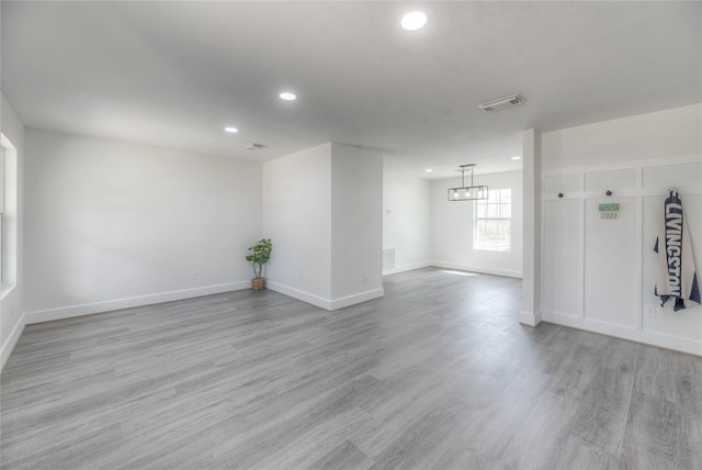 unfurnished room featuring recessed lighting, wood finished floors, visible vents, and baseboards