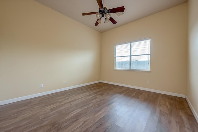 unfurnished room featuring a ceiling fan, wood finished floors, and baseboards