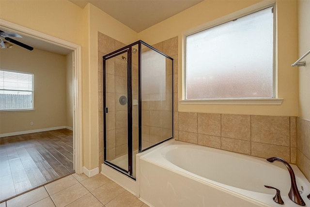 full bath with a garden tub, a ceiling fan, a shower stall, tile patterned flooring, and baseboards