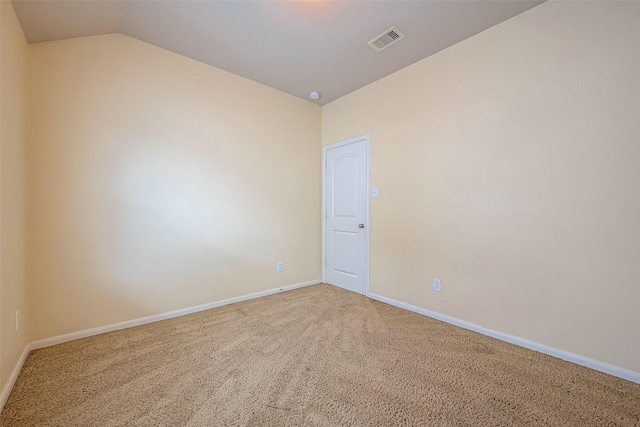 unfurnished room featuring visible vents, baseboards, carpet flooring, and vaulted ceiling