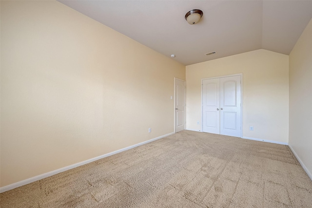 unfurnished bedroom with visible vents, baseboards, vaulted ceiling, carpet flooring, and a closet