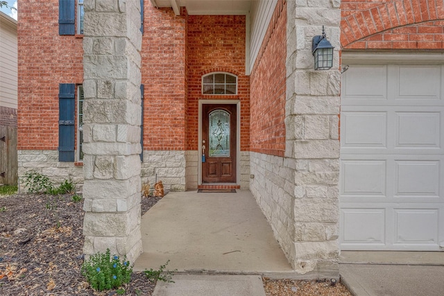 view of exterior entry with stone siding and brick siding