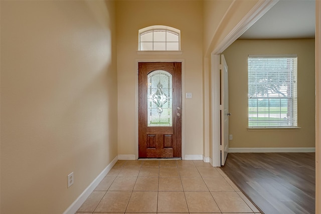 foyer featuring light tile patterned flooring and baseboards