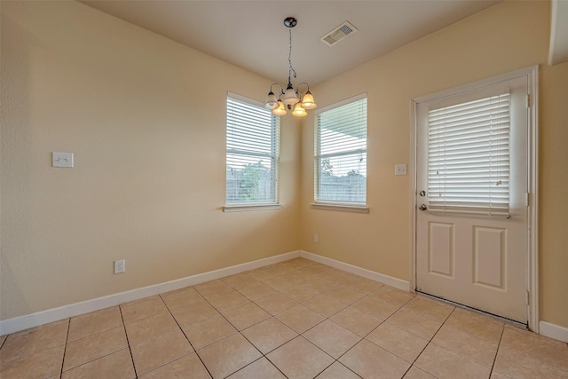 unfurnished dining area with a chandelier, visible vents, baseboards, and light tile patterned floors