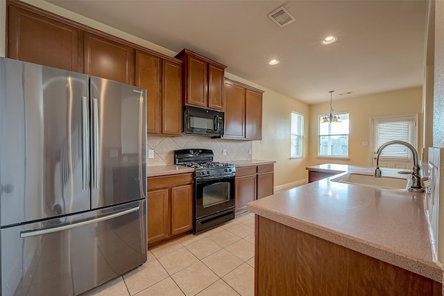 kitchen featuring tasteful backsplash, visible vents, light tile patterned floors, black appliances, and a sink