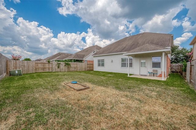 back of property featuring a yard, a patio, and a fenced backyard