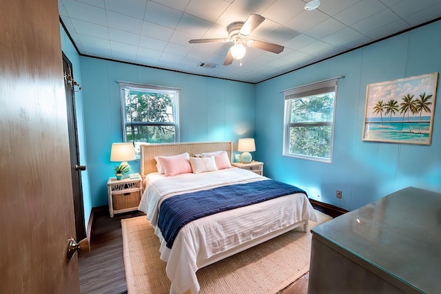 bedroom featuring a ceiling fan, baseboards, visible vents, and wood finished floors