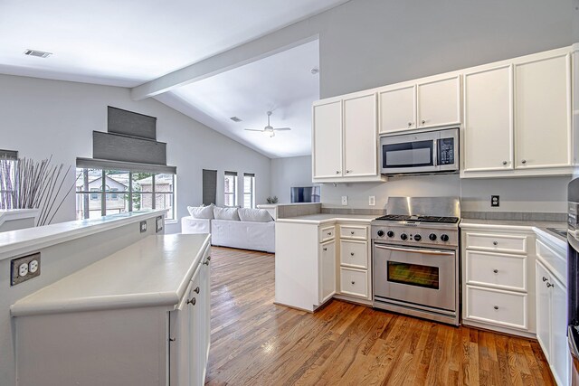 kitchen featuring stainless steel appliances, wood finished floors, visible vents, white cabinets, and open floor plan