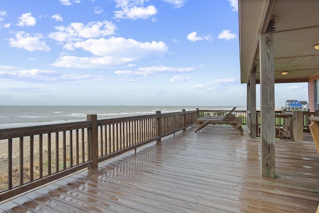 dock area featuring a water view and a beach view