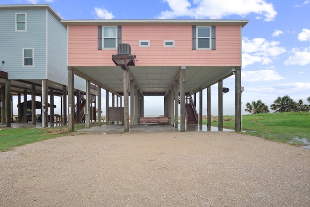 exterior space with dirt driveway, stairs, and a carport