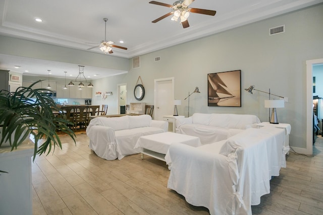 bedroom featuring light wood-style floors, visible vents, a tray ceiling, and recessed lighting