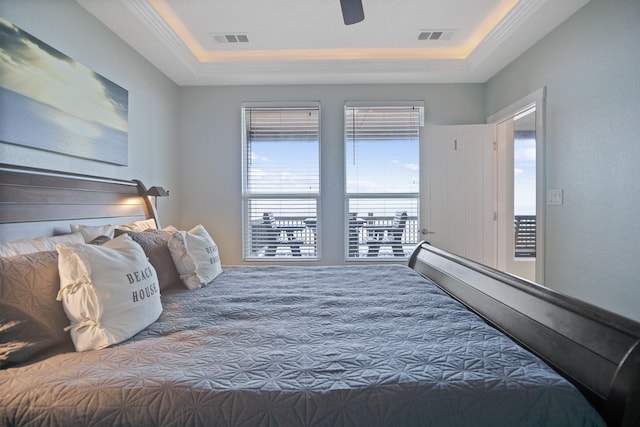 bedroom with a ceiling fan, visible vents, and a tray ceiling