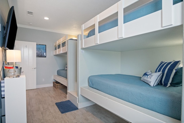 bedroom with light wood finished floors, baseboards, visible vents, ornamental molding, and recessed lighting