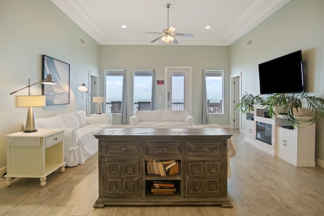 living room with ornamental molding, visible vents, and light wood-style flooring