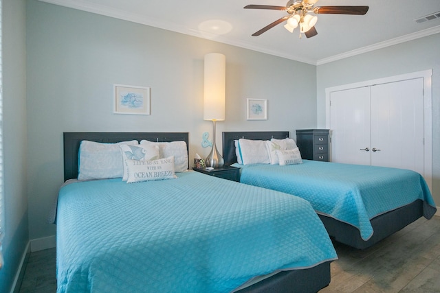 bedroom with visible vents, ceiling fan, wood finished floors, crown molding, and a closet