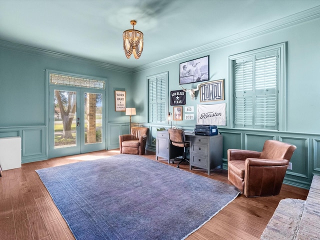 home office with a chandelier, a decorative wall, wood finished floors, ornamental molding, and french doors