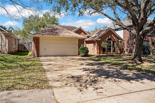 view of front of home featuring a front yard, fence, brick siding, and driveway