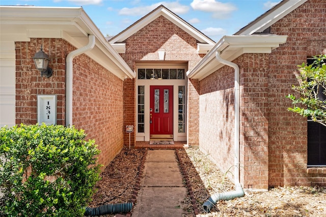 view of exterior entry with brick siding