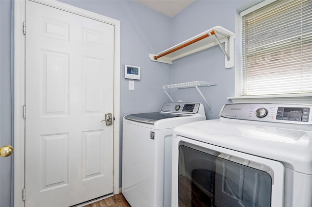 washroom with laundry area, wood finished floors, and washer and clothes dryer