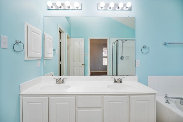 bathroom featuring double vanity, a shower stall, a garden tub, and a sink