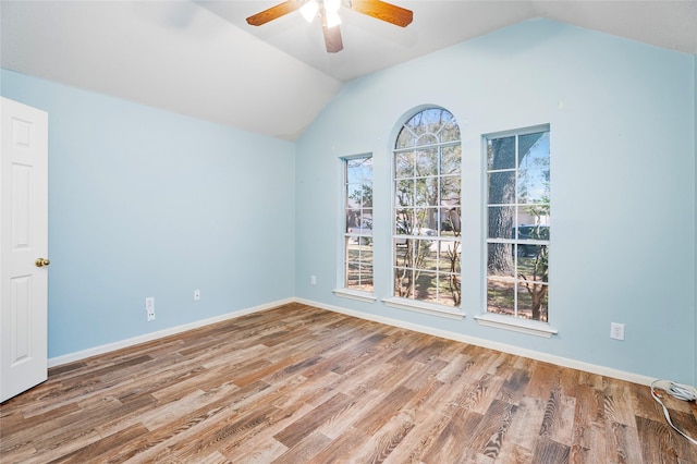 unfurnished room featuring vaulted ceiling, a ceiling fan, baseboards, and wood finished floors