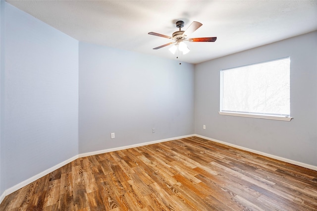 spare room featuring ceiling fan, baseboards, and wood finished floors