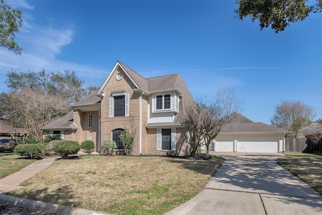 traditional-style house featuring concrete driveway, brick siding, a front yard, and fence