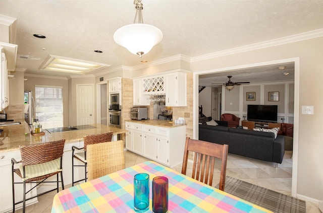 dining space with a ceiling fan, crown molding, and light tile patterned floors